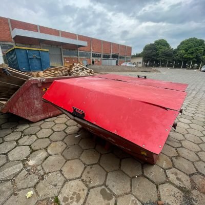 Caçamba de entulho estacionária em pátio de blocos sextavados para reforma comercial na cidade de Avaré.