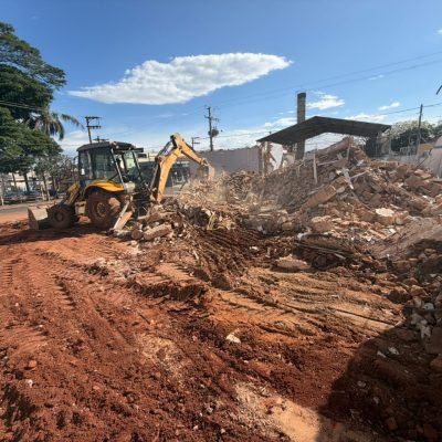 Processo de demolição de estrutura antiga e preparação da área para nova construção comercial urbana.