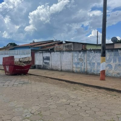 Calçada residencial limpa e organizada com caçamba estacionária vermelha posicionada em rua de Avaré.