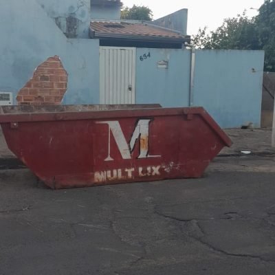 Caçamba estacionária de ferro para coleta de resíduos de construção civil na rua em Arandu.