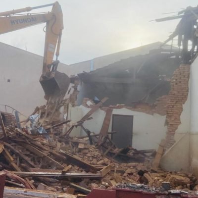 Escavadeira hidráulica da Mult Lix realizando a demolição de estrutura comercial antiga em Cerqueira César.