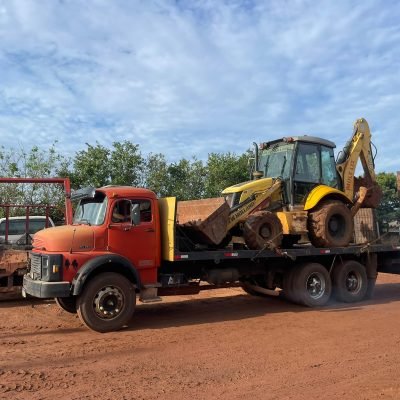 Caminhão prancha carrega-tudo da Mult Lix realizando o transporte de uma escavadeira hidráulica amarela em estrada próxima a Avaré.